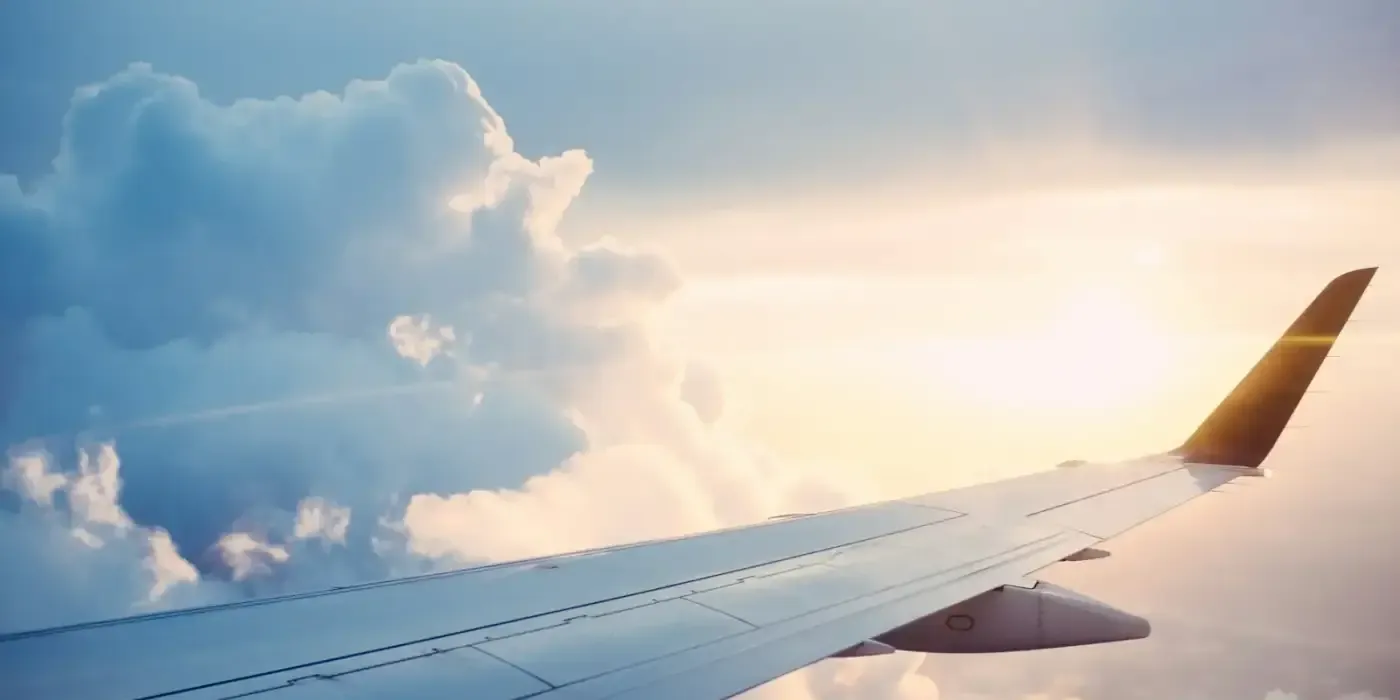 Ala de un avión sobre un mar de nubes al atardecer